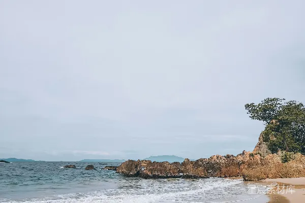 沙滩边紧邻大海下着阴云密布的天空