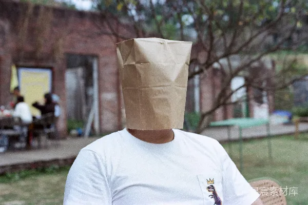 高清摄影 一个人在户外头上戴着一个纸袋。