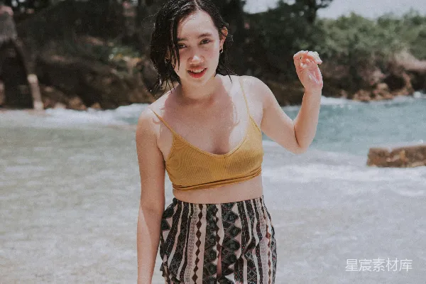 海边一个女子站在水里。