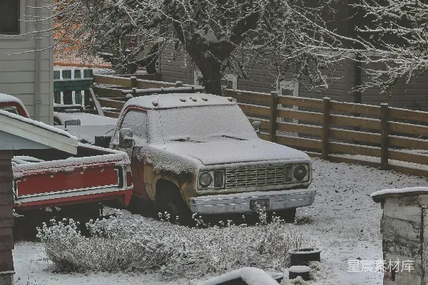 两辆覆盖着积雪的货车停在后院中。