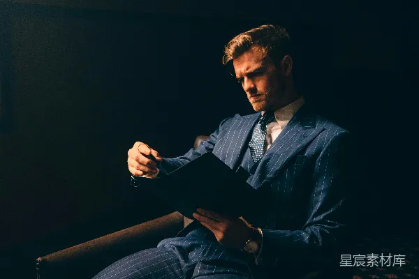 高清摄影 一个穿着西装的男人坐在椅子上。