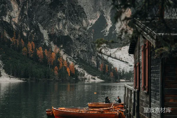高清摄影 一艘红色的小船漂浮在湖面上，旁边是山。