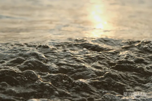 傍晚的海浪轻柔地拍打着沙滩。