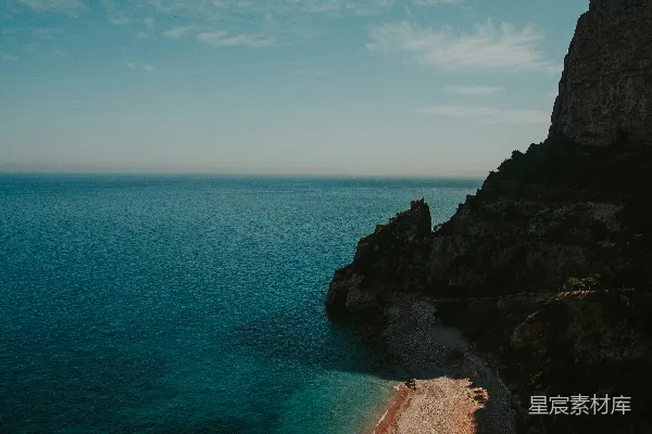 高清摄影 在蓝天下的白天，海边有一块棕色的岩石形成。
