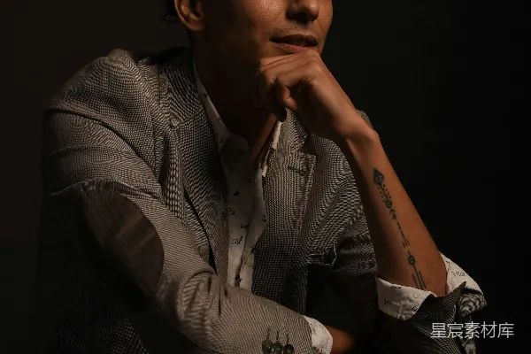 穿着灰色西装夹克的男人坐在椅子上。