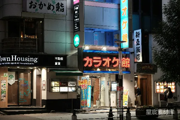 夜晚的城市街道，一幢建筑灯火通明。