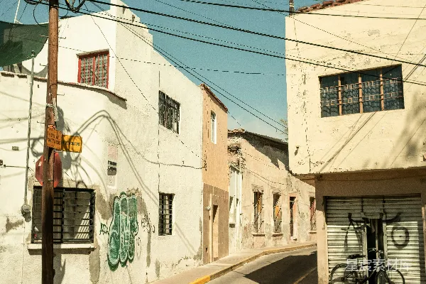 街角有一栋建筑，路边停着一辆自行车。