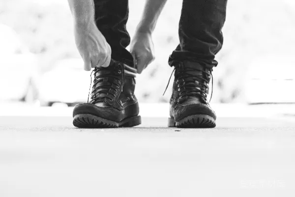 穿着黑色皮带扣靴子的人