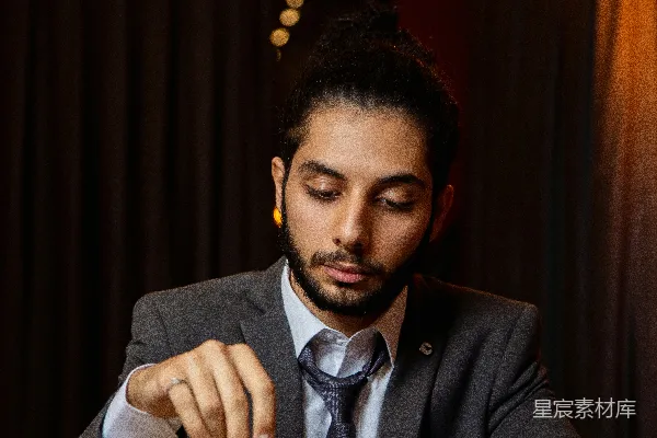 一个穿着西装的男人坐在一张桌子旁