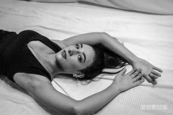 一张黑白照片中一位女性躺在床上的场景