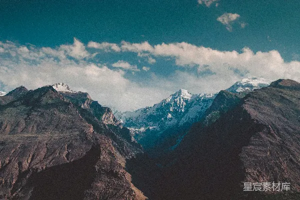 高清摄影 一座山脉，背景中有被雪覆盖的山峰。