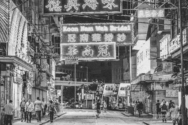 一张黑白照片，夜晚的城市街道。