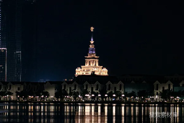 夜晚亮灯的高大建筑中有座钟楼