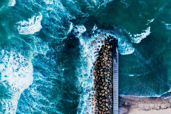 白天海浪在岸边拍打的空中俯视景象