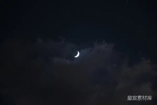 高清摄影 夜晚的天空中，月亮透过云层被看到。