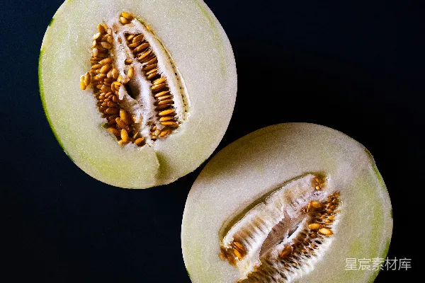 两个哈密瓜半切置于暗背景上