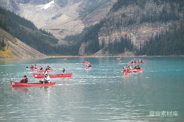 canoes漂浮在一片碧蓝色的湖上，山峦环绕。