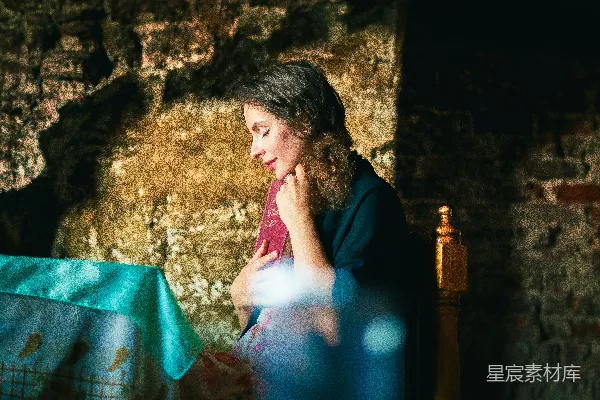一位女士坐在桌子旁盯着笔记本电脑看。