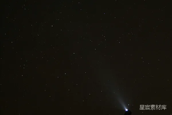 一个站在山丘上的人员手持手电筒。