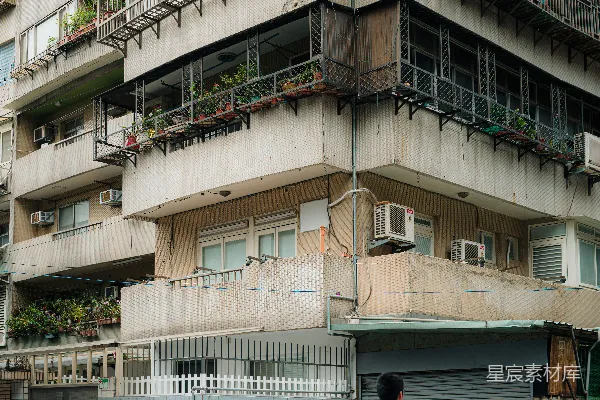 路人走过一幢有阳台的公寓楼。