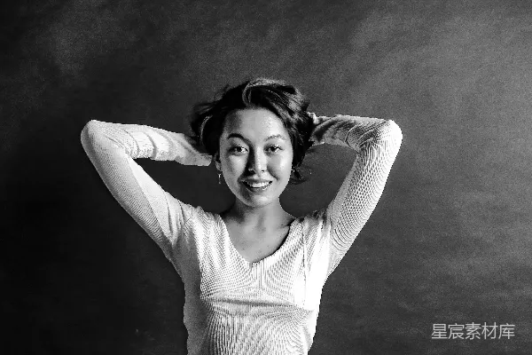 一张黑白照片中一位女子双手放在头上