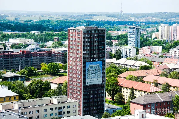 现代摩天大楼矗立在一片蔓延的都市景观中，高高挂着一条条旗帜。