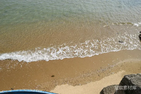 一艘船停在海滩上紧挨着海洋旁边
