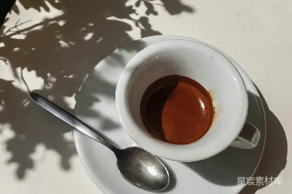 咖啡杯放在托盘上，旁边有一根勺子。