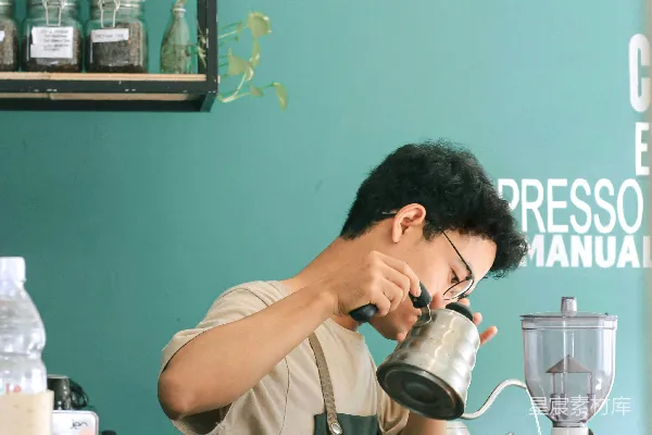 一个男人正在往搅拌机里倒一杯咖啡。