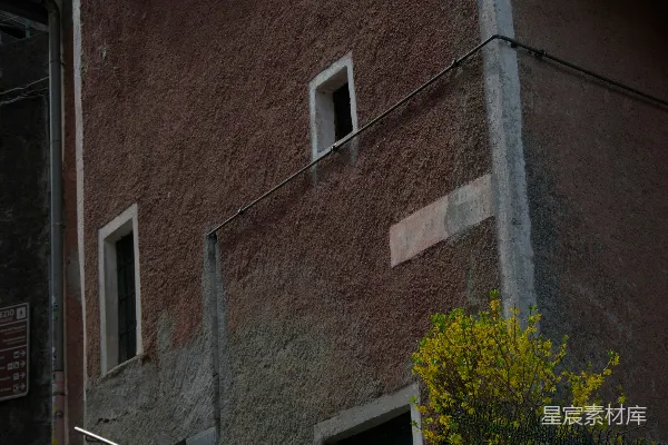 一座用石头台阶搭建的质朴建筑，黄色花朵点缀其间。
