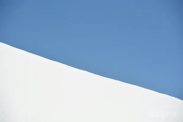 高清摄影 一个男人正在沿着覆盖着积雪的斜坡滑行滑雪板。