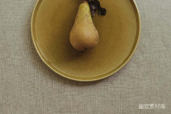 高清摄影 一个黄色的盘子上有一颗梨。