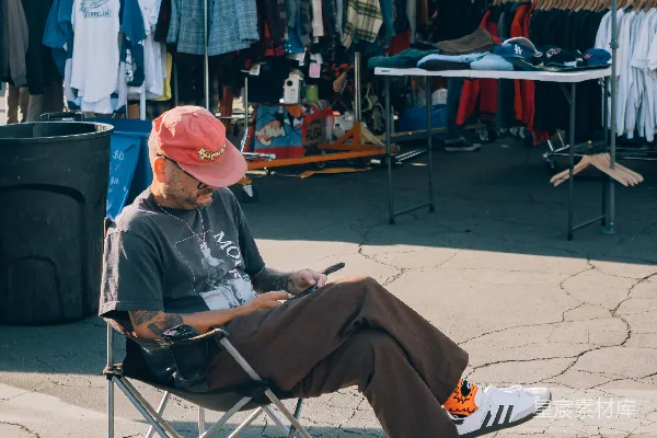 一个男人坐在外面的椅子上。