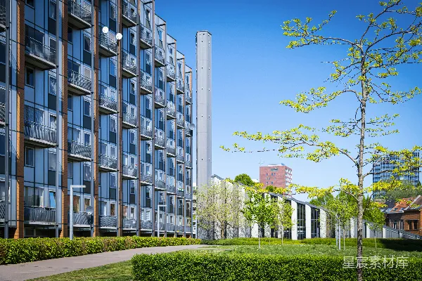 现代公寓建筑，带有绿色庭院和蓝天。