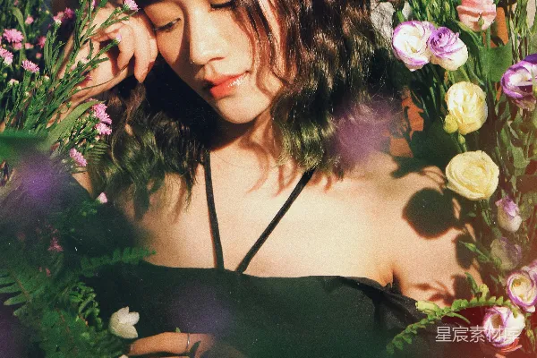 一个女人站在一丛鲜花之中