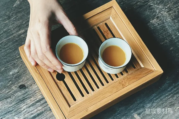 一个拿着两个咖啡杯的托盘的人