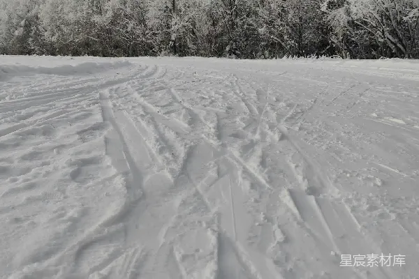 一个骑着滑雪板滑下覆雪斜坡的人