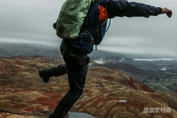 绿衣黑裤的男人站在岩石 Formation 上午时分站立在岩状物上
