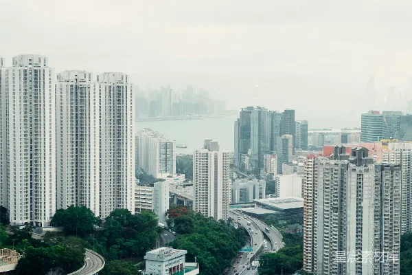 城市风景，高耸的建筑物，繁忙的高速公路和绿色的山丘。