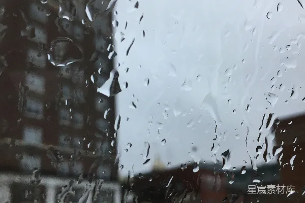 透过蒙上雨水的窗户看的一幢建筑