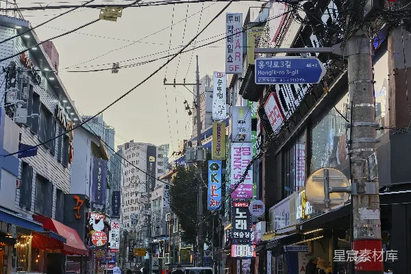 一条街道两旁排列着高大的建筑和许多电线的城市街巷
