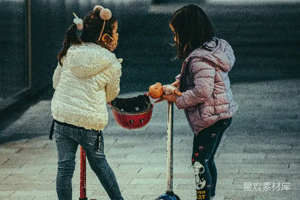 白色夹克的女孩在白天骑着红色的滑板车。