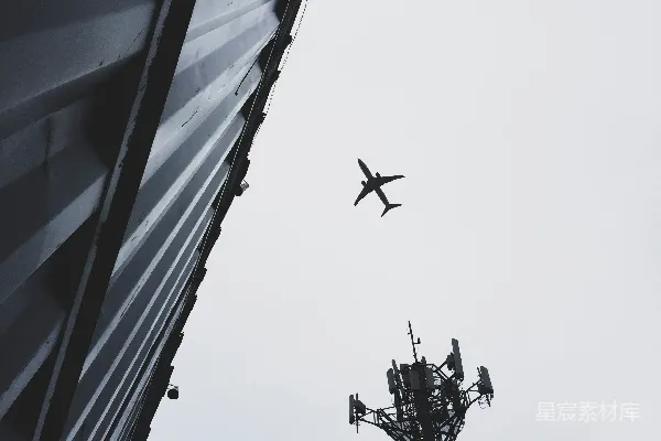 高清摄影 一架飞机正飞过一座高大的建筑。