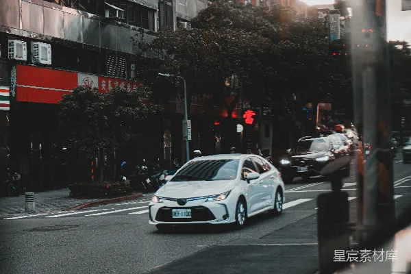 白天在路上行驶的白色轿车