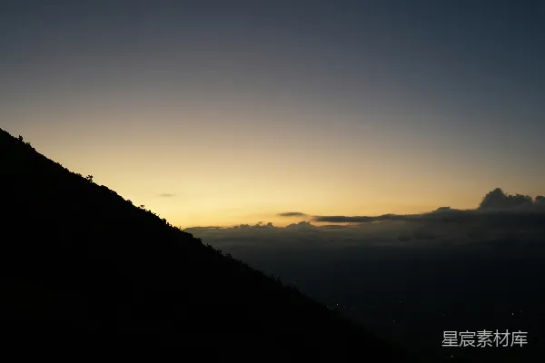 黑暗山影衬托着色彩斑斓的 sunrise 天空与云彩。
