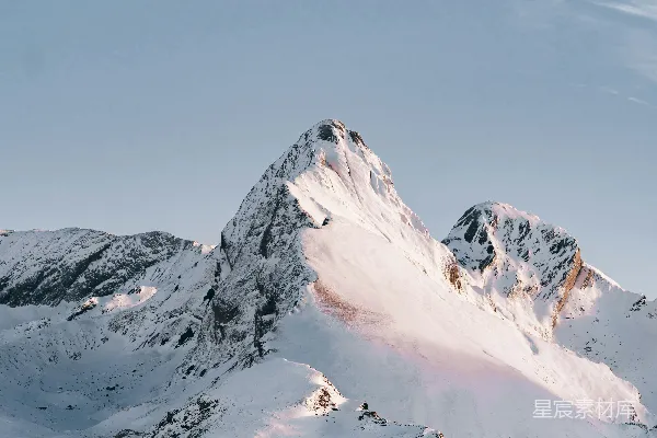 山顶白雪皑皑，蓝天白云。