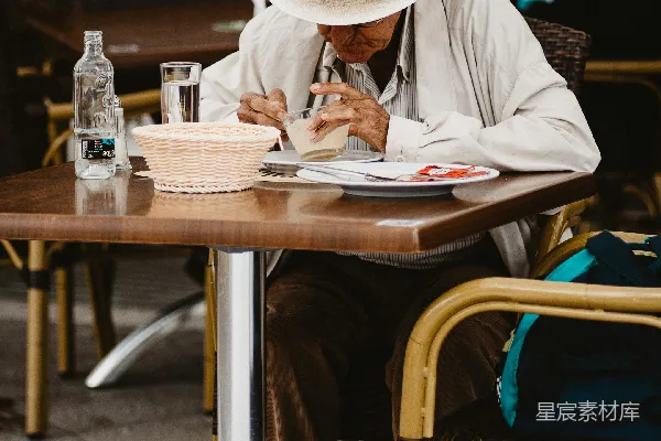 白衬衫男子穿着蓝色直筒牛仔裤坐在棕色木椅上阅读报纸