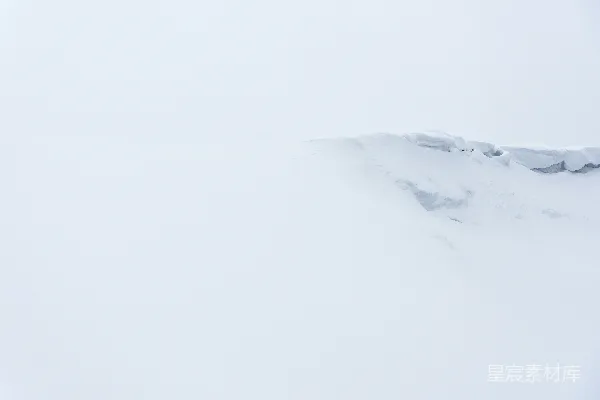 一个男人在覆雪的山坡上滑雪下滑
