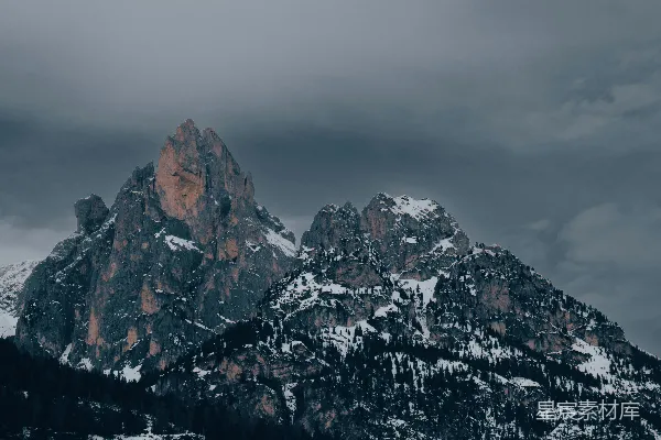 皑皑白雪覆盖的山峦下是阴云密布的天空