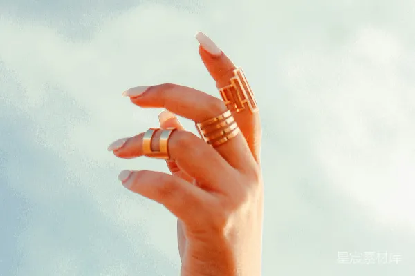 一个女人的手在空中拿着一枚戒指